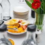 An elegant dining setup featuring fresh fruits and vibrant tulips, perfect for a healthy meal.